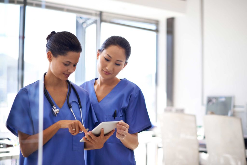 Two female nurses discussing a chart